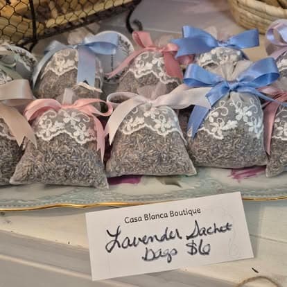 Many bags of tea sitting on a table with a sign.