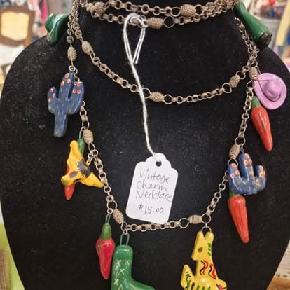 A black mannequin with a lot of charms on it.